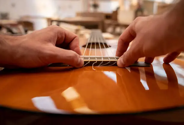 Photo of Close-up on a man fixing a guitar