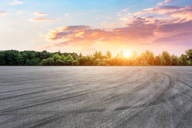 Empty race track and green forest with beautiful clouds at sunset