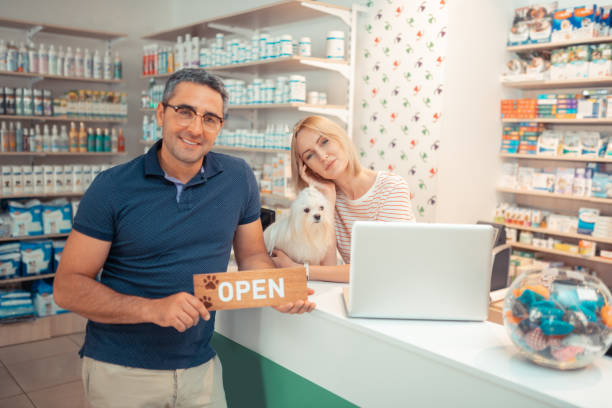 Couple of entrepreneurs greeting customers after opening pet shop Greeting customers. Couple of successful young entrepreneurs greeting customers after opening pet shop pet shop photos stock pictures, royalty-free photos & images
