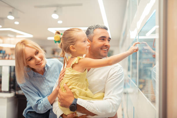 istock Girl touching window while looking at parrots with parents 1164461639