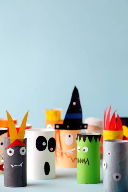 istock Halloween crafts, paper ghost, monsters on blue paper background with copy space for text. halloween concept handcraft, diy, creative idea from toilet tube, recycle 1164462418