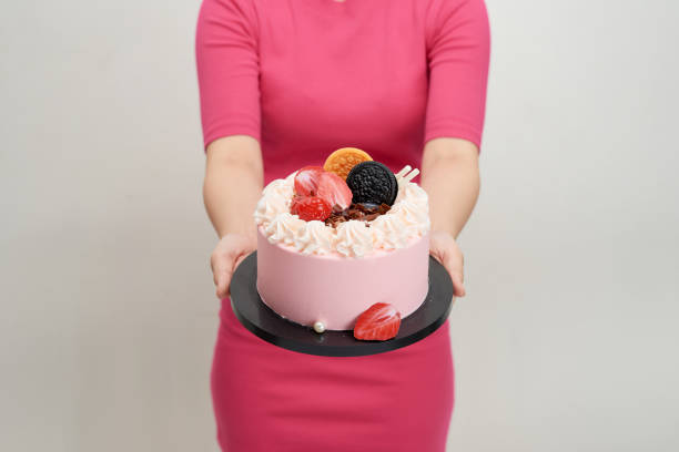 istock Woman holds birthday cake in her hands 1164462608