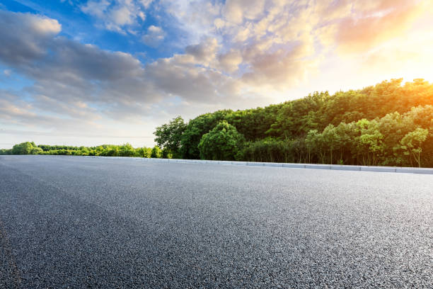 istock Asphalt highway and green forest with beautiful clouds at sunset 1164465848