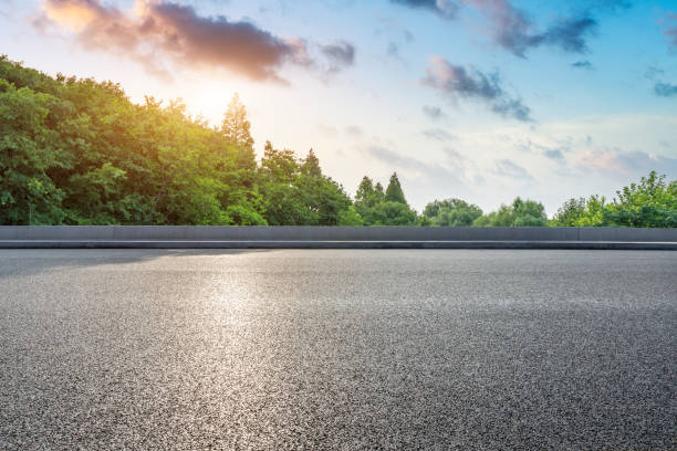 istock Asphalt highway and green forest with beautiful clouds at sunset 1164465966