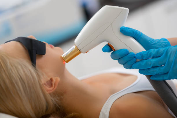 istock Cosmetologist giving her client laser face treatment. 1164467812
