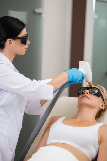 istock Beauty doctor with laser standing above her patient. 1164467821
