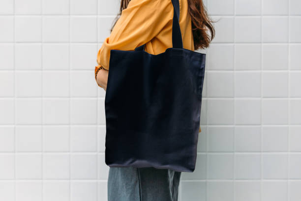 istock Woman is holding black bag canvas fabric for mockup blank template. 1164469931