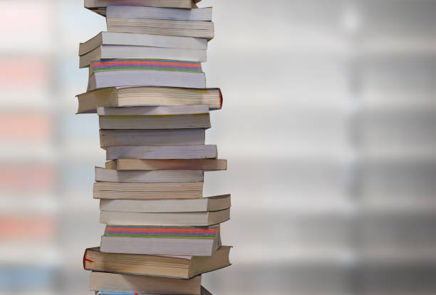 istock Stacking books with blur bookshelfs background in library room. 1164475337