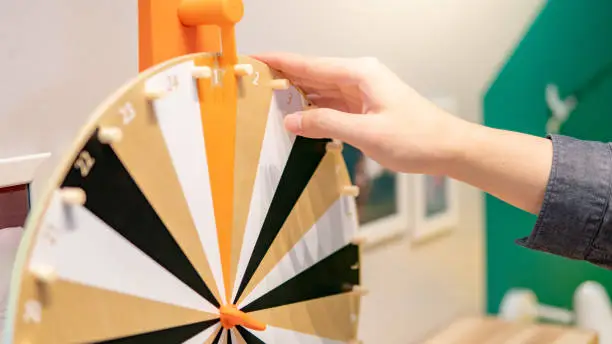 Photo of Male hand spinning wooden wheel of fortune