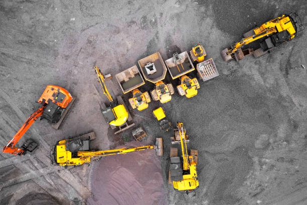 Construction site diggers yellow and orange aerial view from above Construction site diggers yellow and orange aerial view from above uk construction equipment photos stock pictures, royalty-free photos & images
