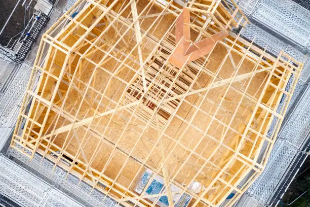 Wooden roof truss beams during construction building of a house aerial view uk
