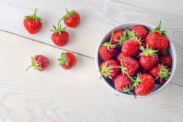 istock Fresh strawberries in a bowl on a wooden table. close-up 1164491496