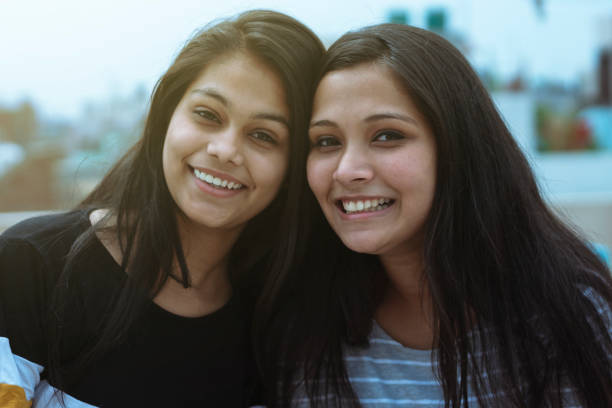 istock two beautiful multiethnic girl toothy smiling and looking at camera 1164494089