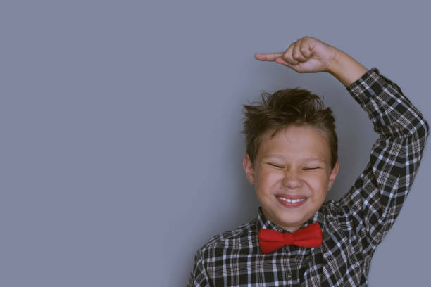 istock Young schoolchild pointing up portrait 1164496531