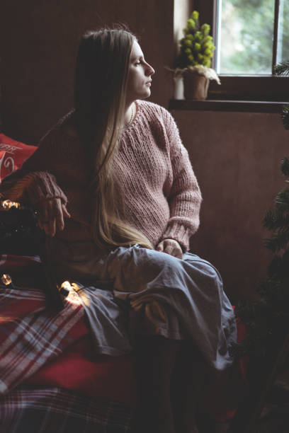 istock girl by the window at christmas 1164496704