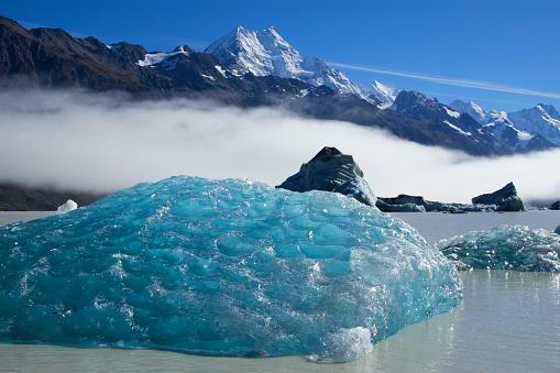 Blue Iceberg floats at the foot of Tasman Glacier below Mt Cook in New Zealand