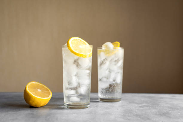 Tom Collins Cocktail Tom Collins Cocktail or Gin Tonic Cocktail with lemon in classic glasses, copy space. gin tonic stock pictures, royalty-free photos & images