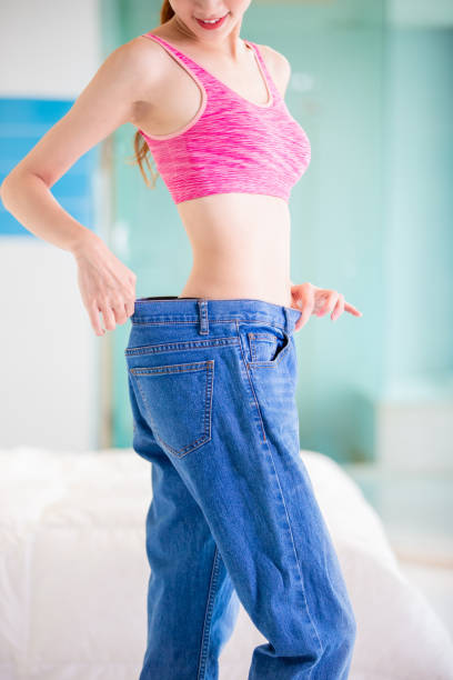 istock woman show her big jeans 1164500335
