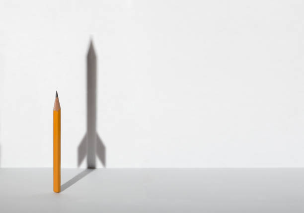 A hand is holding a pencil ready to draw, isolated on white background.