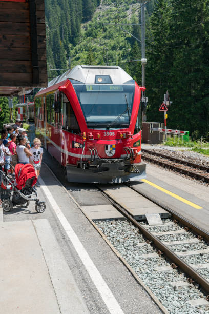 赤いラチア鉄道の列車は、風光明媚なクールに沿って乗客をピックアップするためにリツィルエティに停止 - アローザ線 - rhätische bahn ストックフォトと画像