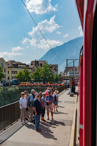 赤いラチア鉄道の列車は、風光明媚なクールに沿って乗客をピックアップするためにクールに停止 - アローザ線 - rhätische bahn ス��トックフォトと画像
