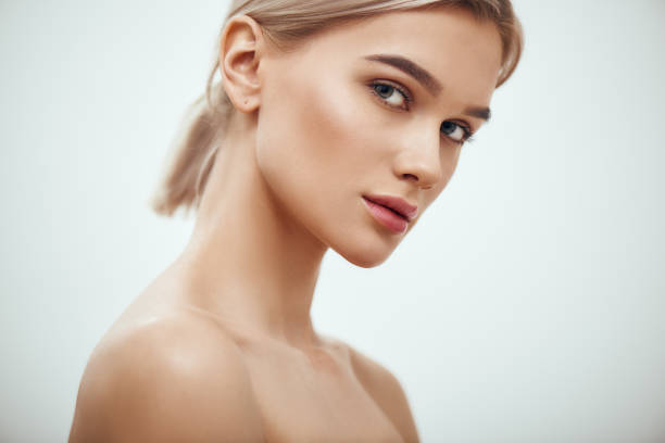 je me sens belle. jeune femme blonde magnifique avec la peau parfaite regardant l'appareil-photo tout en restant sur le fond gris - beautifully photos et images de collection