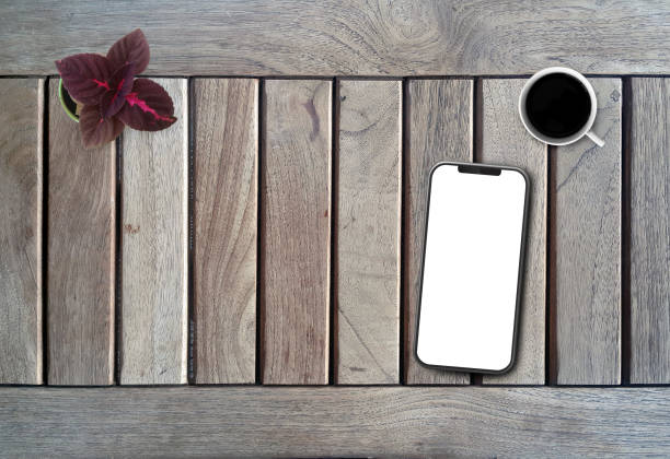 istock Top View of Office Desktop With Blank Screen Mobile Phone 1164513413