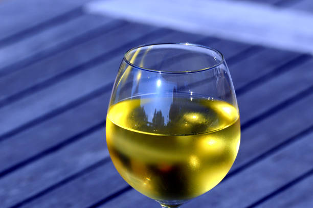 Cold glass of white wine served at wooden table