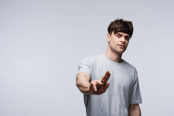 istock displeased man showing stop gesture isolated on grey, human emotion and expression concept 1164514606