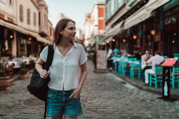 istock Smiling woman with a backpack exploring an old town 1164514721