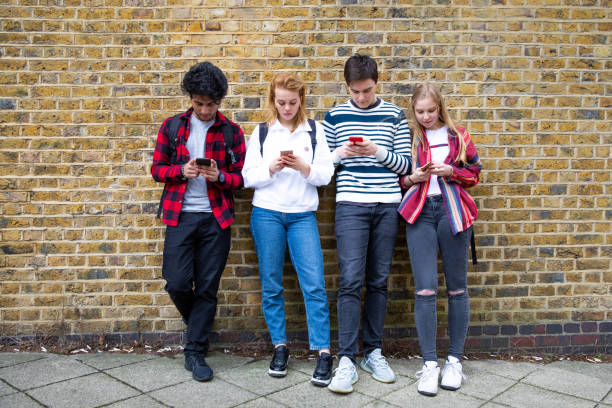 grupo de amigos adolescentes se centró en sus propios mensajes de texto de teléfonos inteligentes en las redes sociales - adicto grupo de jóvenes amigos usando teléfonos móviles fotografías e imágenes de stock