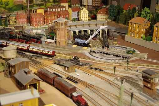 Model of a steam locomotive and passenger cars on rails on a white background