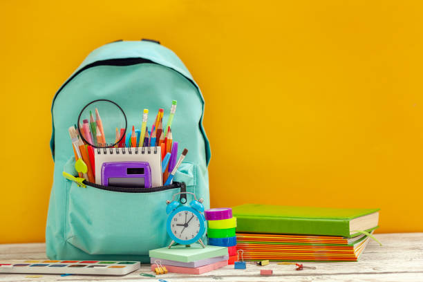 istock Full School Backpack with different supplies on orange background. Concept back to school. 1164521179