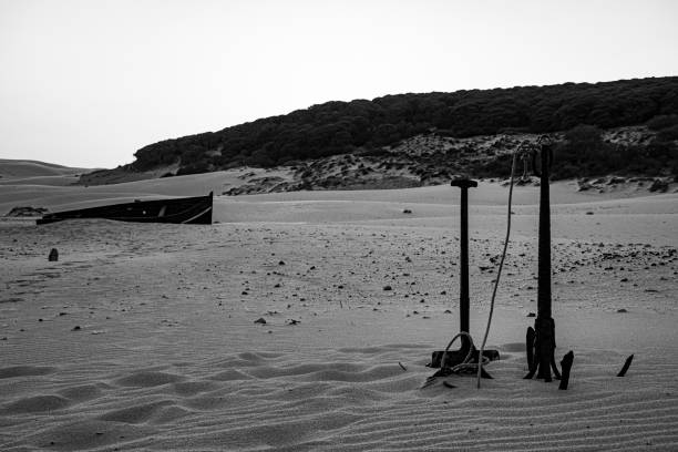Anchor in the sand vintage anchor and rusty shovel abandoned in the sand dunes of Bolonia in Spain kitchen utensil antique toaster old stock pictures, royalty-free photos & images