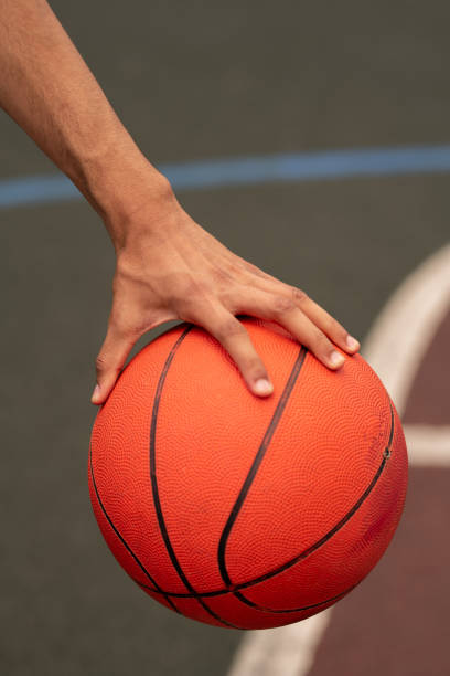istock Hand of young active basketballer holding ball while getting ready to throw it 1164525225