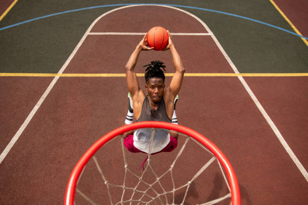 istock African young basketballer making effort while throwing ball in basket 1164525260