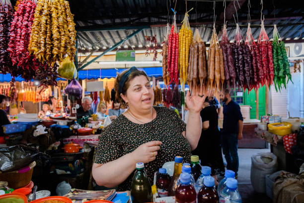 georgischer markt. verkäuferin zeigt das sortiment von churchkhela für käufer - ajaria stock-fotos und bilder