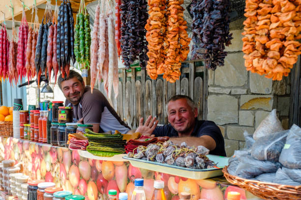 homem georgian idoso que trabalha na tenda pequena do alimento da rua no quadrado em mtskheta - ajaria - fotografias e filmes do acervo