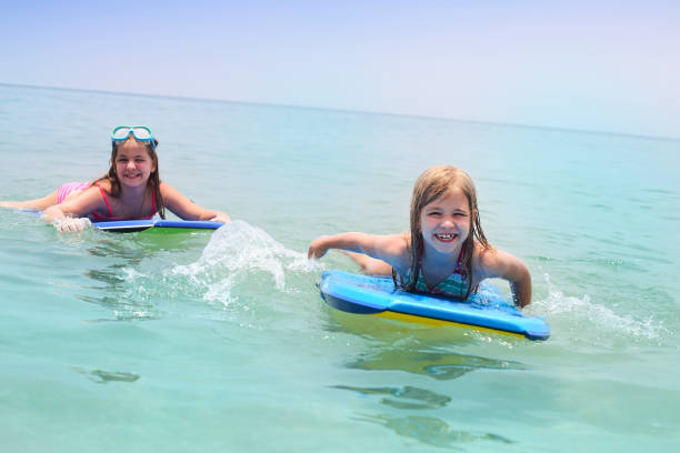 istock Children learning to swim and surf with body board 1164527428
