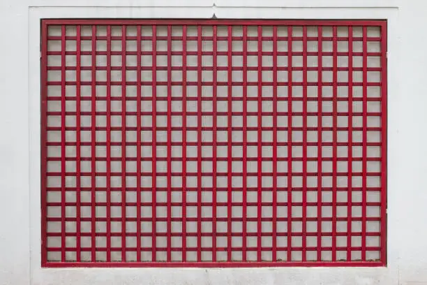 Photo of red steel grid on white wall