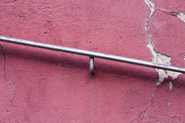 istock Iron handrail in a violet cracked wall background (Germany, Europe) 1164527796