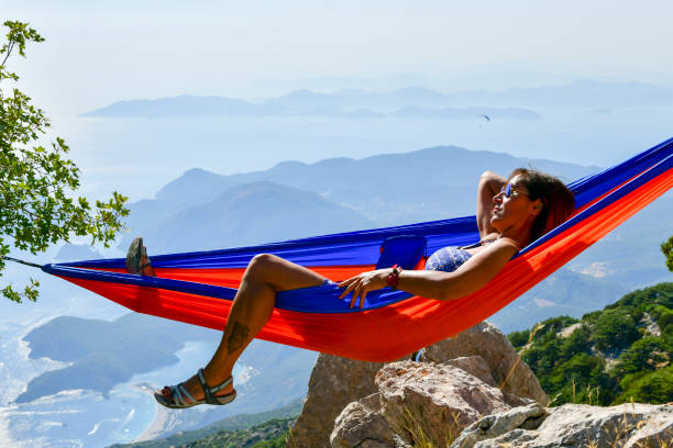 istock Happy woman in hammock looking at view. 1164529006