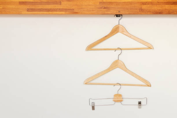istock Wooden clothes hangers on minimal open closet storage. 1164538136
