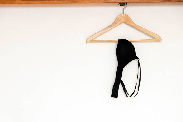 istock Black bra hanging on wood hanger on minimal open closet storage. 1164538147