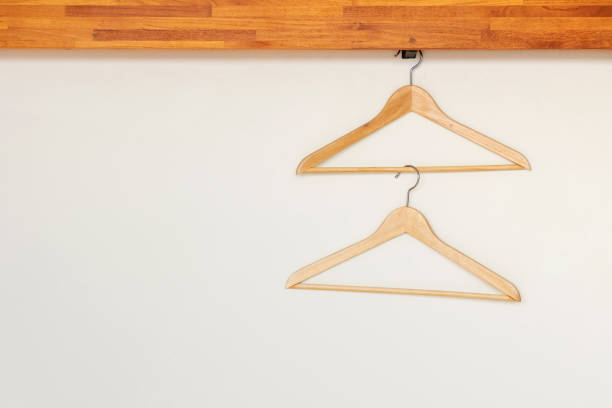istock Wooden clothes hangers on minimal open closet storage. 1164538155