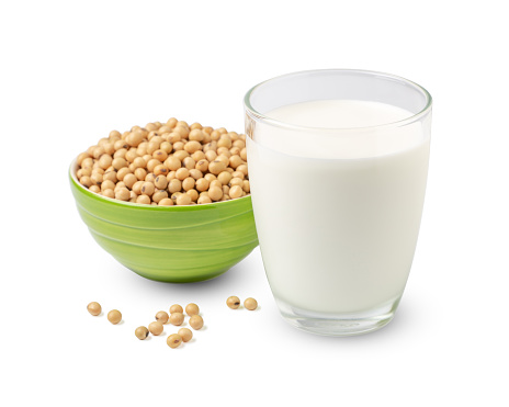 Glass of Soy milk with soybeans in green bowl isolated on white background.