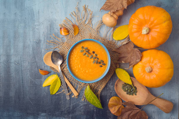 istock Pumpkin soup on rustic background. Autumn concept with pumpkin and fall leaves. Top view from above 1164543855