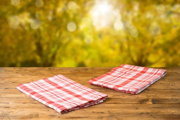 istock Empty wooden table with tablecloth over autumn nature park background 1164543856