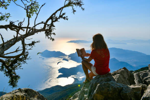 istock Woman studying book on top of mountain. 1164549185
