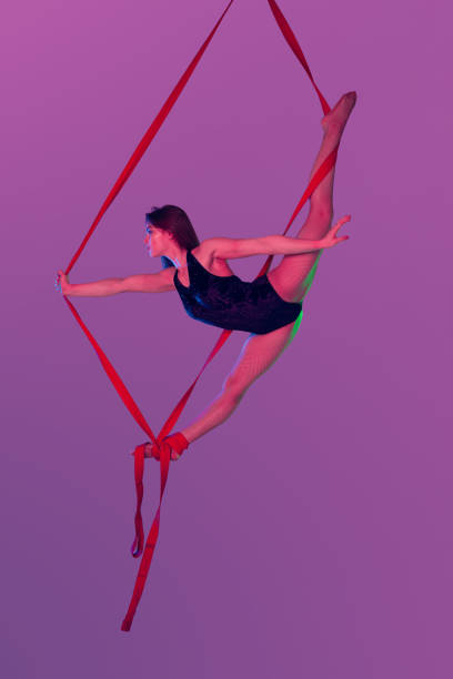 istock Beautiful girl in a black swimsuit is performing an acrobatic elements in studio 1164550417